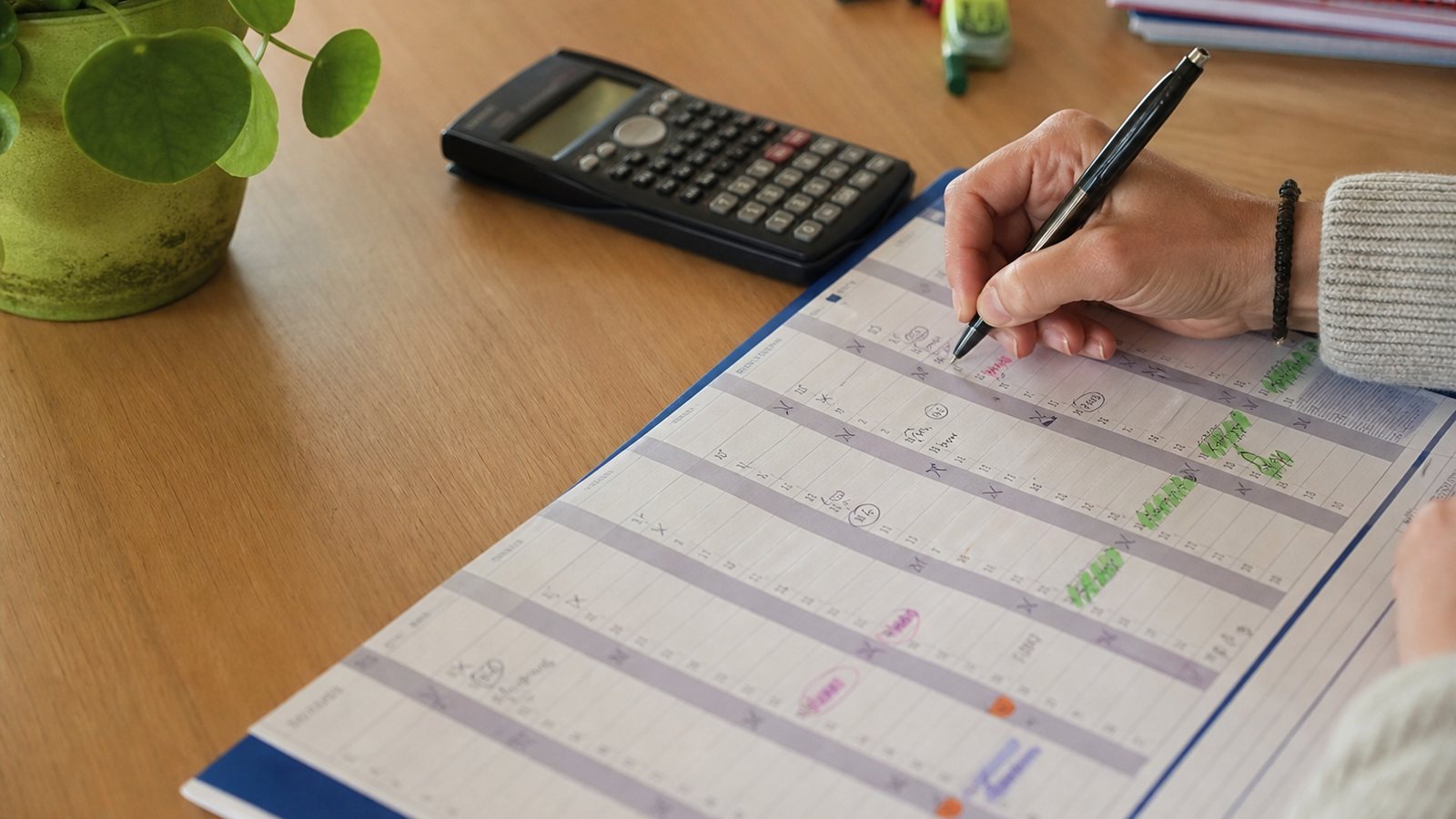 Gestionnaire calculant un solde de congés payés avec une calculatrice et un calendrier